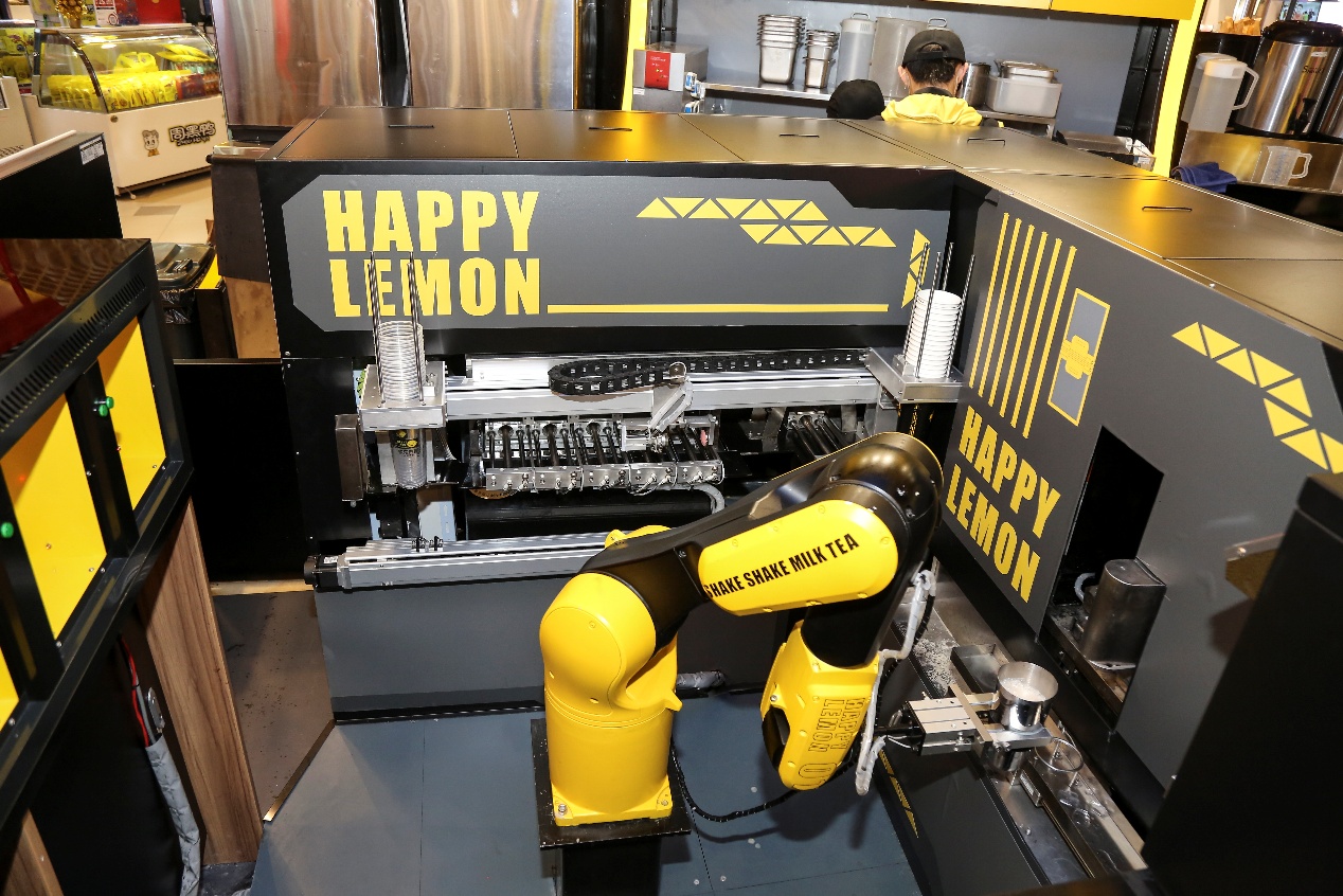 D:\口碑\2019年智慧餐厅项目\3月快乐柠檬智慧餐厅\快乐柠檬照片\奶茶机器人正在通过自动化的加料程序，为消费者制作奶茶。.jpg