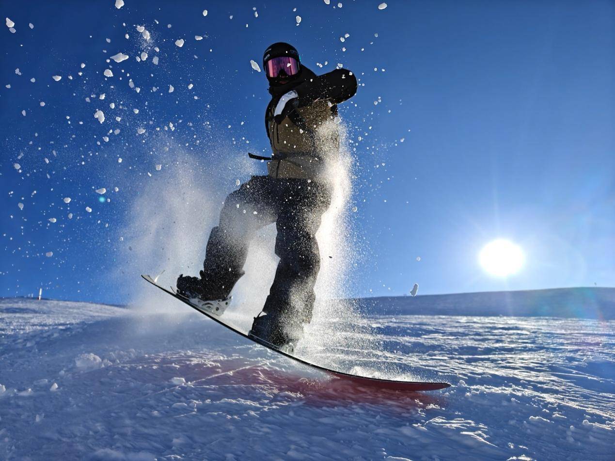 雪地里有男人在跳起來滑雪描述已自動生成