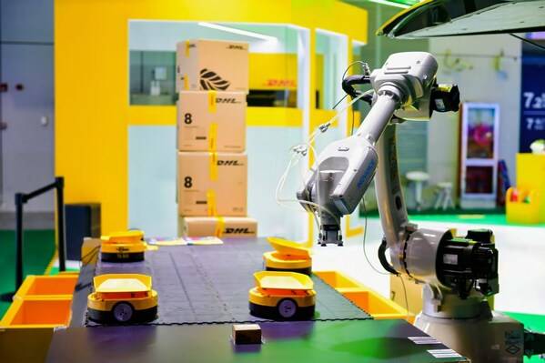 进博会DHL快递展台上机械臂与AGV小车协同工作，模拟仓库分拣作业场景